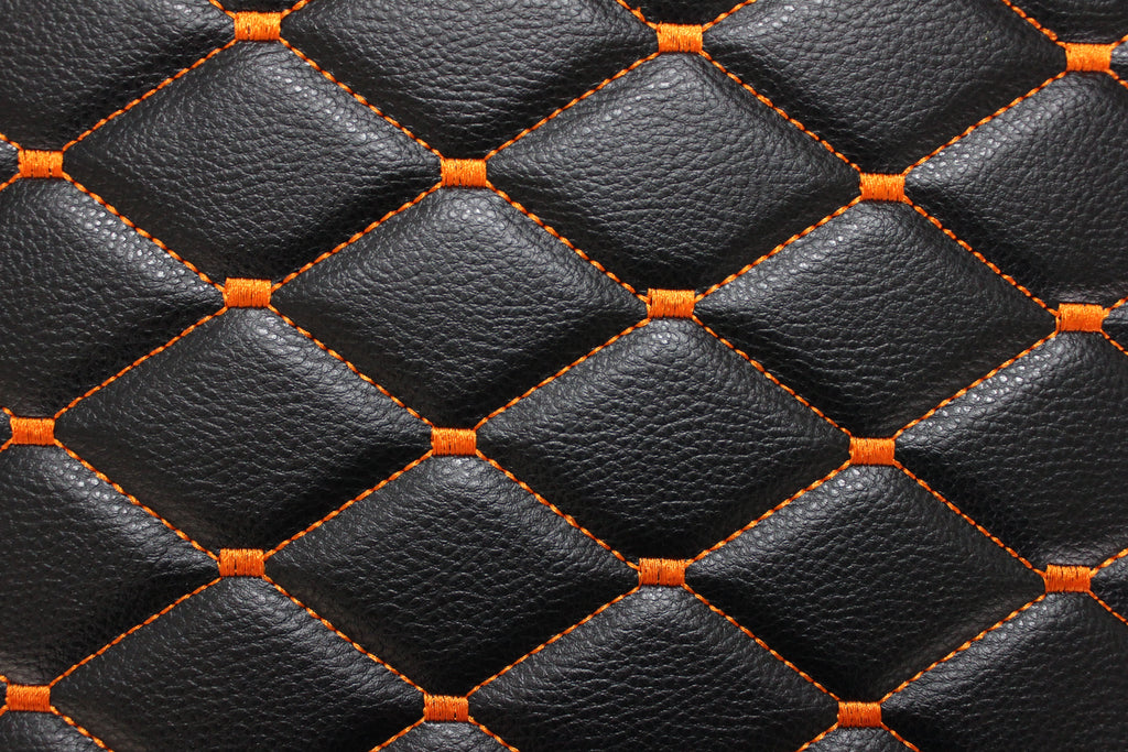Tecido para estofos automóveis em vinil preto acolchoado laranja com textura granulada | Costura em losango de 5x8cm com espuma | 140cm e 55,1" de largura | Pele sintética (réplica)