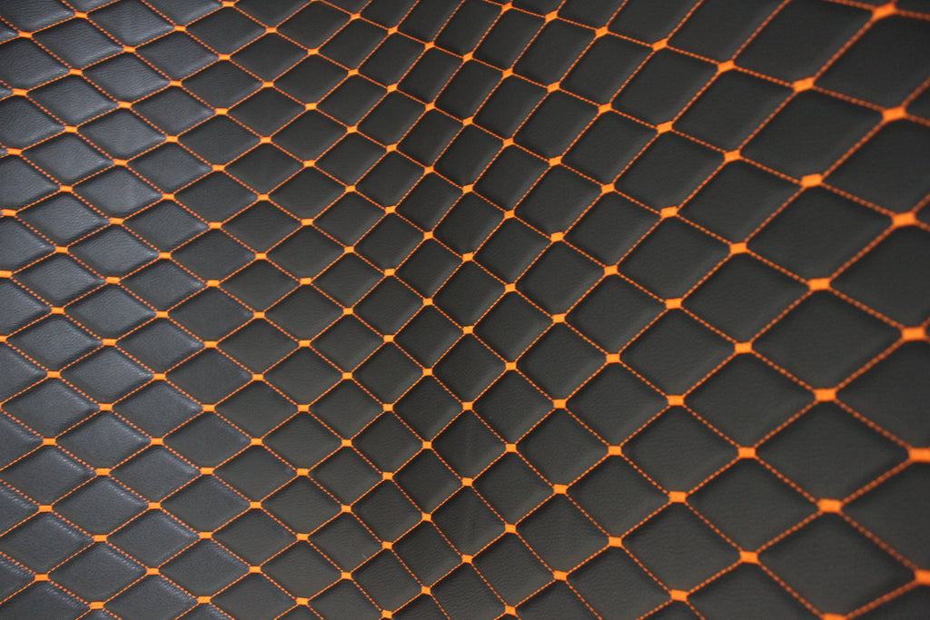 Tecido para estofos automóveis em vinil preto acolchoado laranja com textura granulada | Costura em losango de 5x8cm com espuma | 140cm e 55,1" de largura | Pele sintética (réplica)