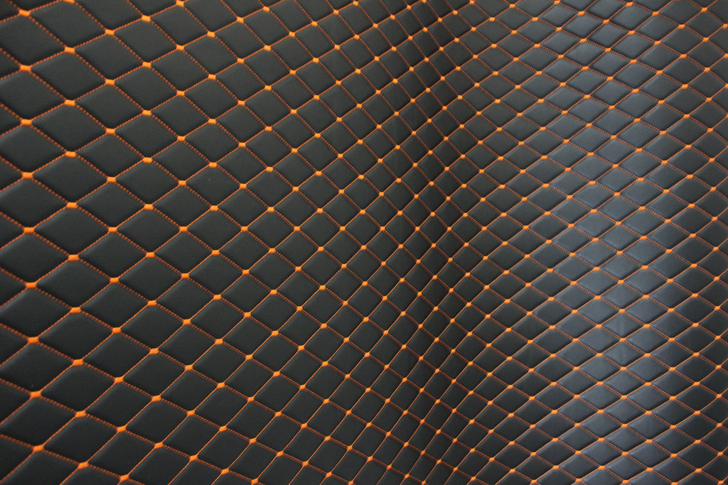 Tecido para estofos automóveis em vinil preto acolchoado laranja com textura granulada | Costura em losango de 5x8cm com espuma | 140cm e 55,1" de largura | Pele sintética (réplica)