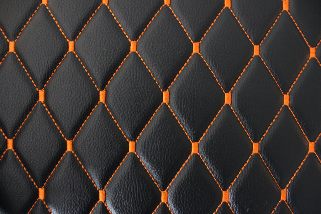 Tecido para estofos automóveis em vinil preto acolchoado laranja com textura granulada | Costura em losango de 5x8cm com espuma | 140cm e 55,1" de largura | Pele sintética (réplica)