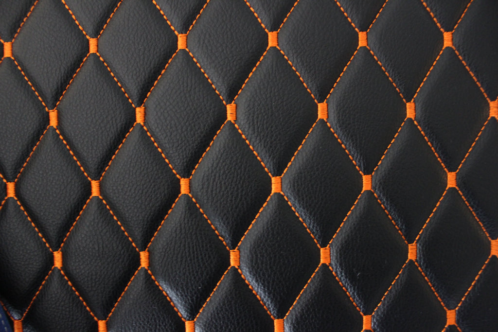 Tecido para estofos automóveis em vinil preto acolchoado laranja com textura granulada | Costura em losango de 5x8cm com espuma | 140cm e 55,1" de largura | Pele sintética (réplica)